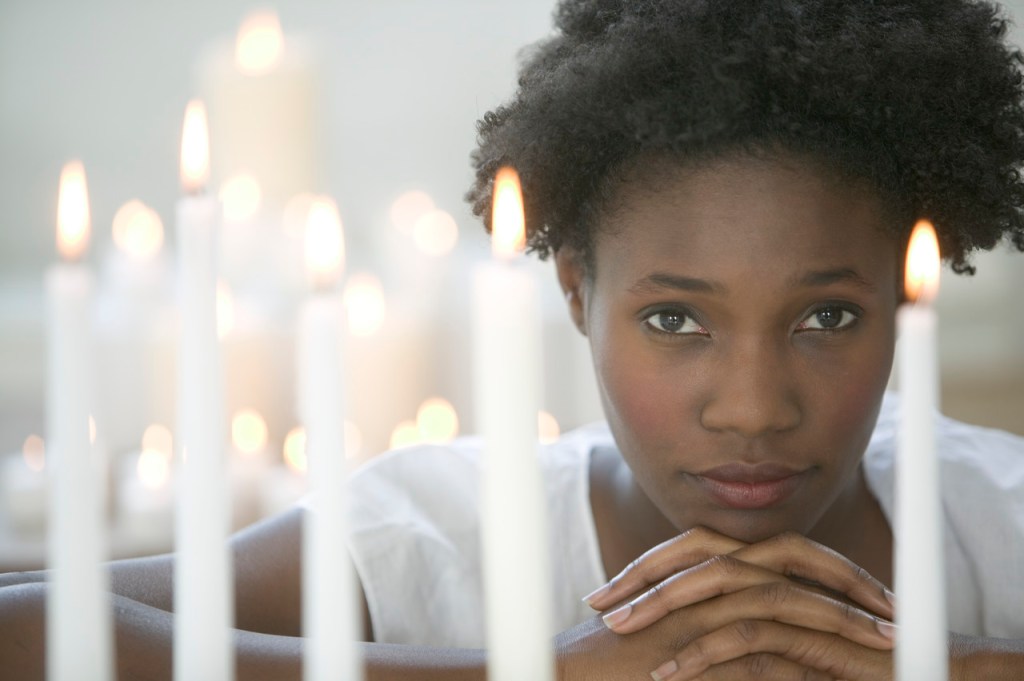 Woman Among Lit Votive Candles
